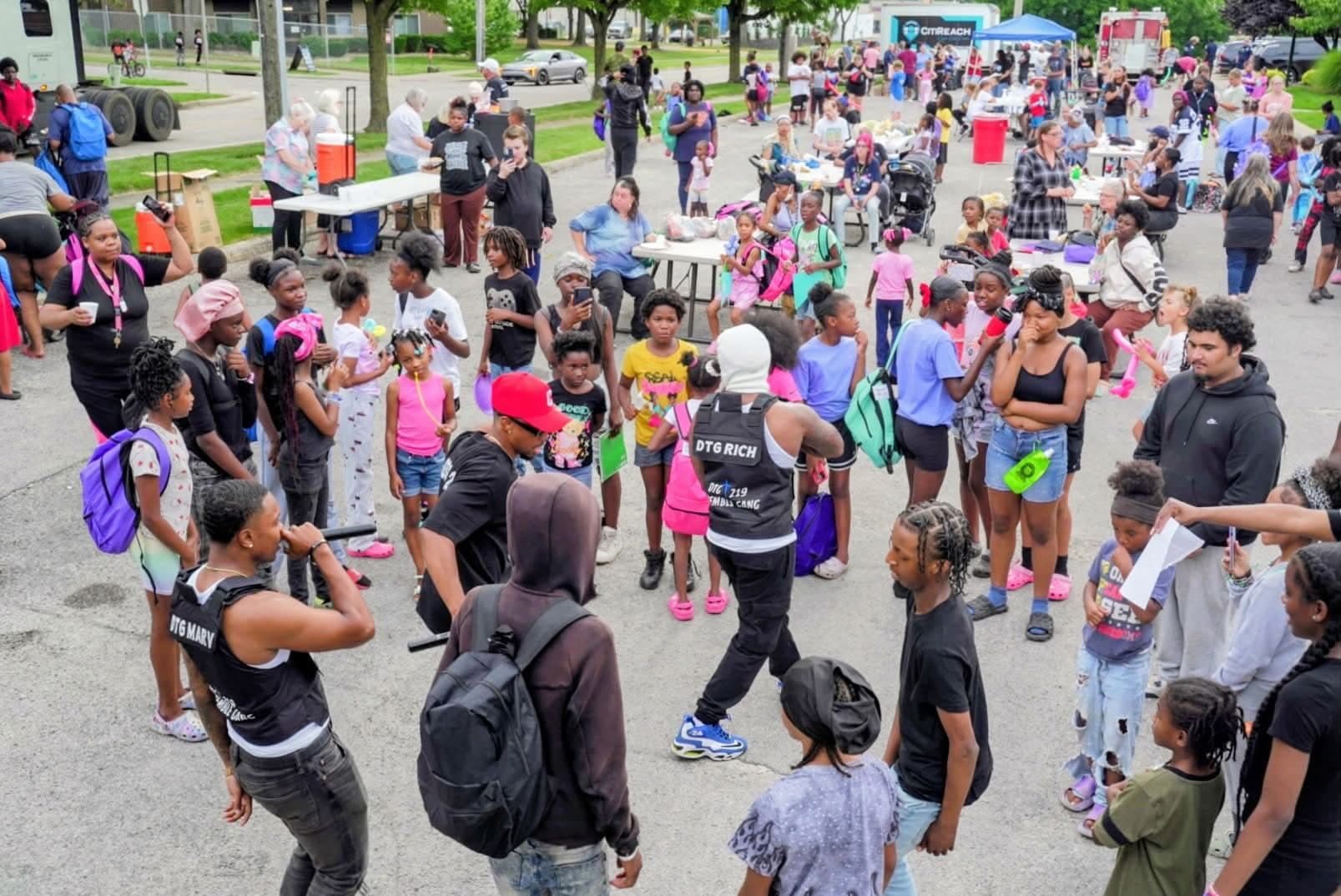 Artists with microphones perform for kids and families at a CitiReach block party.